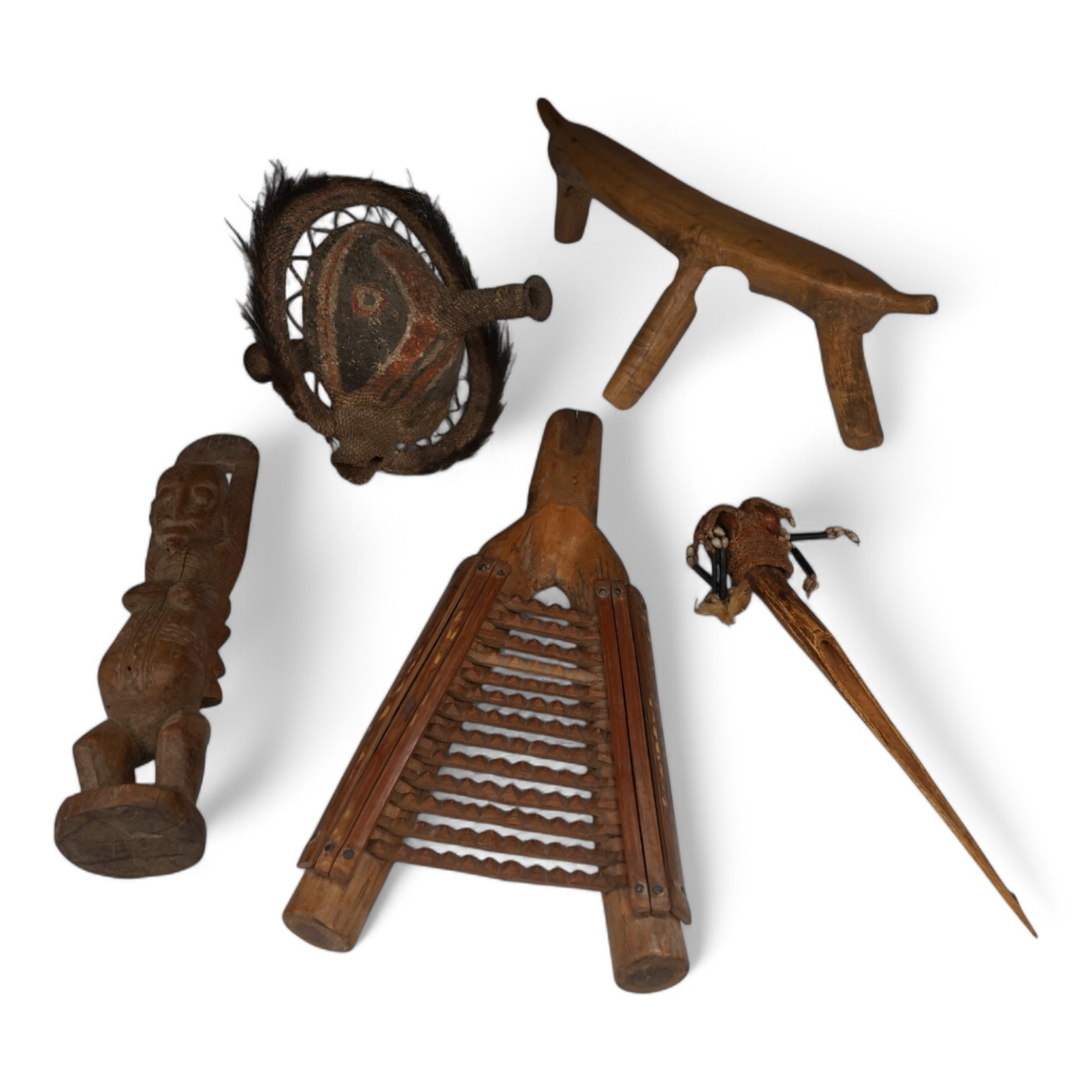 A Papua New Guinea ceremonial bone dagger, a painted straw mask, a tribal instrument and a carved stool. Condition - fair/good